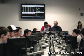 Visitors observe a trading competition, which simulates a real-world trading floor, in the MB Building.
